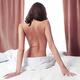 Nude back of woman sitting on bed in front of window... (thumbnail)