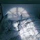 Unmade bed with light coming from a window... (thumbnail)