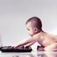 Cute baby in diaper playing with computer... (thumbnail)