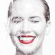 Artistic portrait of a smiling woman with water running over her face... (thumbnail)
