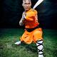 Shaolin warrior monk holding a stance with a broad sword... (thumbnail)