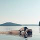Woman practicing yoga on platform in the water Matsyasana Fish pose... (thumbnail)
