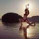 Woman doing yoga Anjaneyasana Low Lunge pose on the water in morning s... (thumbnail)