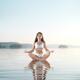 Woman practicing morning sunrise meditation on the water... (thumbnail)