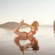 Woman practicing yoga on platform in the water Bow Dhanurasana pose... (thumbnail)