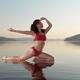 Woman practicing yoga on platform in the water doing Pigeon pose varia... (thumbnail)