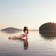 Woman practicing yoga on platform in the water Upward Facing Dog pose... (thumbnail)