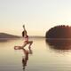Woman practicing yoga on the water Anjaneyasana Low Lunge pose... (thumbnail)