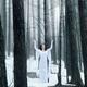 Woman standing in a forest with her arms raised... (thumbnail)