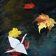 Origami paper crane on autumn leaf in a stream... (thumbnail)