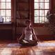 Woman meditating at home in dramatic dim light... (thumbnail)