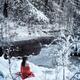 Woman in red kimono sitting in snow by a river... (thumbnail)
