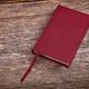 Red hardcover book on wood background... (thumbnail)