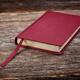 Red hardcover book on wooden background... (thumbnail)