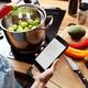 Woman cooking reading recipe from iPhone 7... (thumbnail)