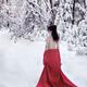 Woman in red kimono lowered down to her waist walking away in snow... (thumbnail)