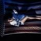 Woman reading a book in a hammock at night in dim light... (thumbnail)