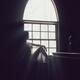 Beautiful woman sitting on a window sill in bright sunlight... (thumbnail)