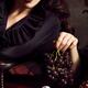Femme fatale woman with dark lips holding black grapes in her hand... (thumbnail)