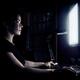 Woman face illuminated by the computer screen in dark of a night... (thumbnail)