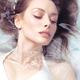 Portrait of a beautiful young woman with fresh clean face lying in wat... (thumbnail)