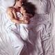 Couple sleeping together in bed in morning sunlight... (thumbnail)