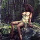 Beautiful young woman sitting on a rock in a forest in a sensual relax... (thumbnail)