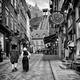 Two persons dressed in medieval costumes walking up the Rue Sous Le Fo... (thumbnail)