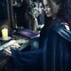 Woman reading Tarot cards at a table... (thumbnail)