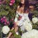 Beautiful sexy woman in a wet summer dress sitting on stairs in a rose... (thumbnail)