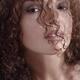 Sensual beauty face portrait of a young woman looking through her curl... (thumbnail)
