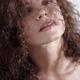 Natural beauty portrait of curly long hair covering young woman face... (thumbnail)