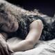 Sensual candid portrait of a young beautiful woman lying on a bed in u... (thumbnail)