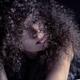 Sensual expressive portrait of a woman lying on a bed her face covered... (thumbnail)
