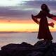 Woman in red dress flying in the wind dancing in sunset on the ocean s... (thumbnail)