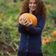 Young woman with a pumpkin at a farm in fall... (thumbnail)