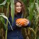 Smiling young woman with a pumpkin at a farm in fall... (thumbnail)