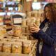 Woman at a grocery store looking at canned food products... (thumbnail)