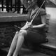 Elegant woman in a dress sitting on the street under umbrella with a p... (thumbnail)