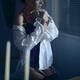 Sensual portrait of a woman in mens shirt and sexy corset sitting by t... (thumbnail)