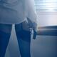 Sexy woman standing by the window with a gun in her hand wearing shirt... (thumbnail)