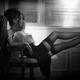 Beautiful sexy woman sitting with her legs in stockings on a desk in d... (thumbnail)