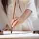 Artistic closeup of woman sumi-e artist hand with brush painting on ri... (thumbnail)