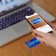 Woman with iPhone X in her hand scanning credit card with Apple Wallet... (thumbnail)
