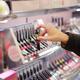 Woman taking lip gloss lipstick tester in a Japanese makeup store... (thumbnail)