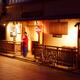 Woman welcoms guests by the entrance of traditional Japanese restauran... (thumbnail)