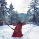 Asian woman in red kimono dancing on the snow in the forest... (thumbnail)