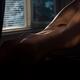 Art nude photo of a sexy beautiful woman body in a dark room lit by a... (thumbnail)