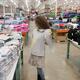 Woman trying on a sweater at Costco Wholesale warehouse store clothing... (thumbnail)