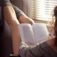 Legs of a woman reading a book in a chair by the window... (thumbnail)